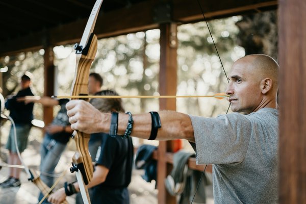 What are the critical factors in selecting the right type of bow for competitive archery?